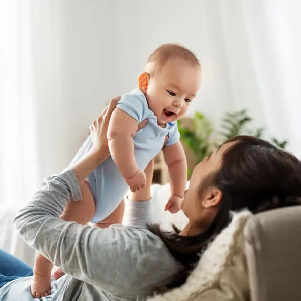 AIMH | Image showing a mother holding a baby up to look into the babies eyes
