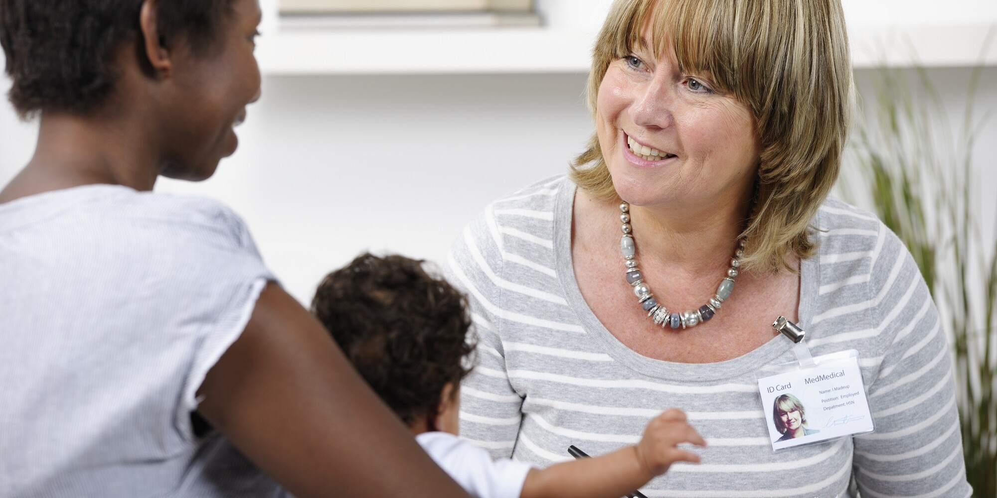 Health Visitor/ Healthcare Worker Giving Advice To A New Mother