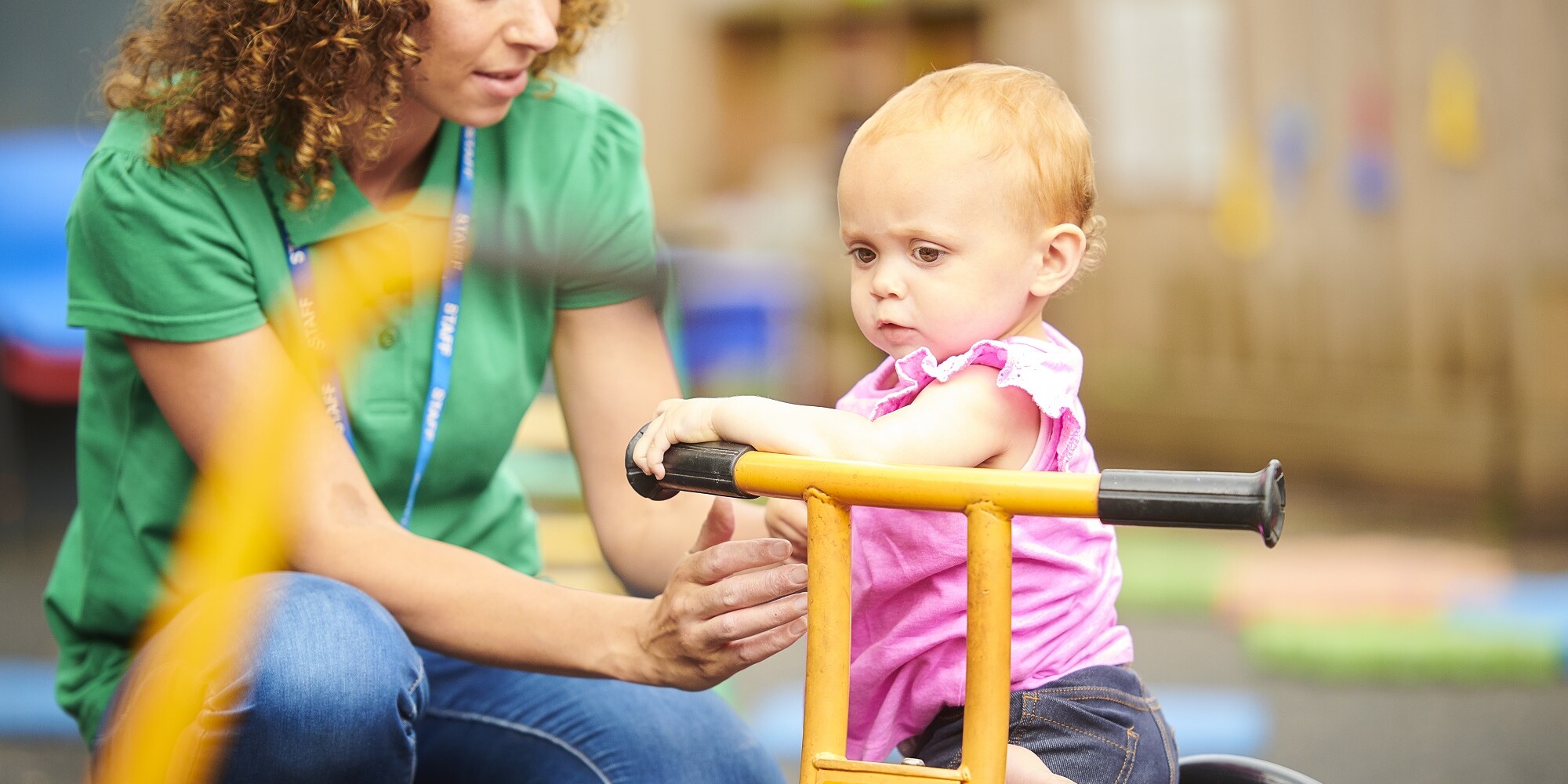 nursery worker with child in playground