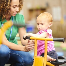 nursery worker with child in playground